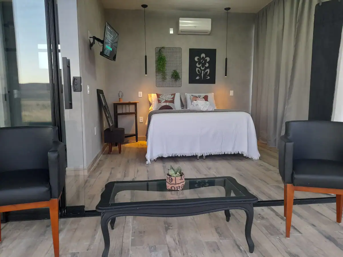 Quarto com cama de casal e vista para o campo